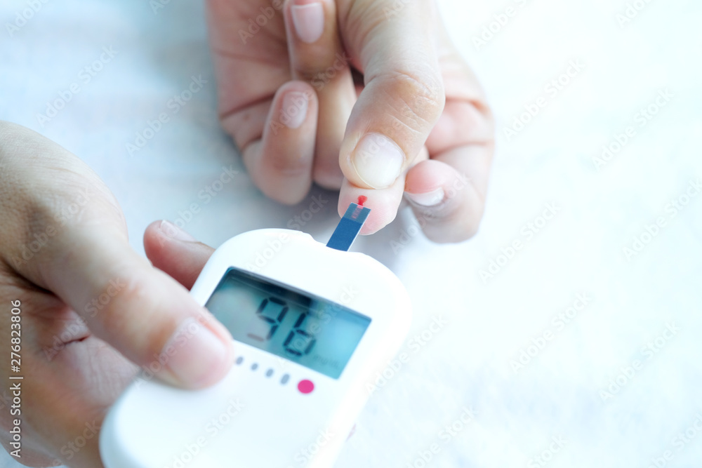 hand of people check diabetes and high blood glucose monitor with digital pressure gauge. Healthcare and Medical concept hand of people check diabetes and high blood glucose monitor with digital pressure gauge. Healthcare and Medical concept