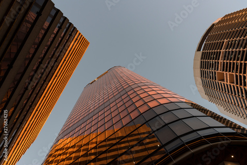 Buildings downtown reflecting the orange of sunset.