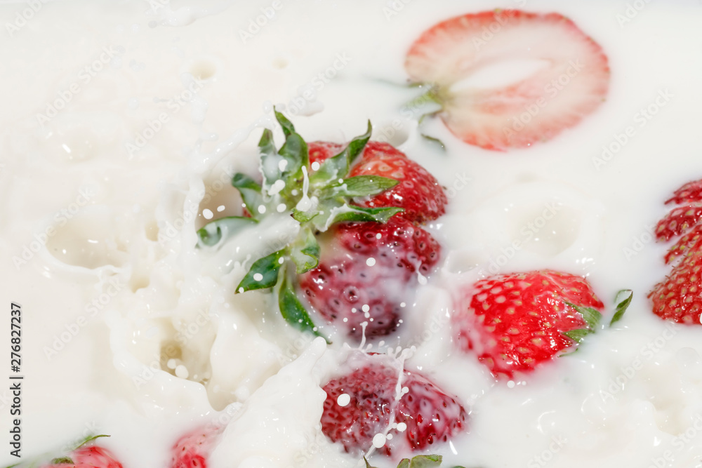 Red natural ripe strawberries falling into milk cream Red natural ripe strawberries falling into milk cream