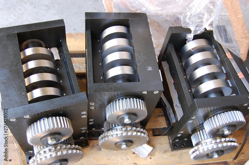 three industrial roller modules with gear gears on a wooden pallet