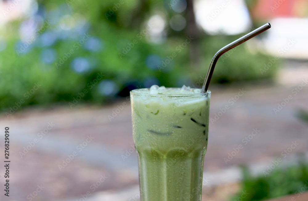 Iced green tea in crystal glass with stainless steel straw for drink. Concept for reduce plastic pollution and support green eco friendly products. Iced green tea in crystal glass with stainless steel straw for drink. Concept for reduce plastic pollution and support green eco friendly products.