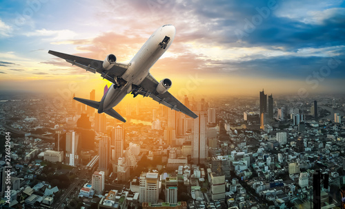 Canvas Print Airplane flying above Bangkok city in beautiful sunset light