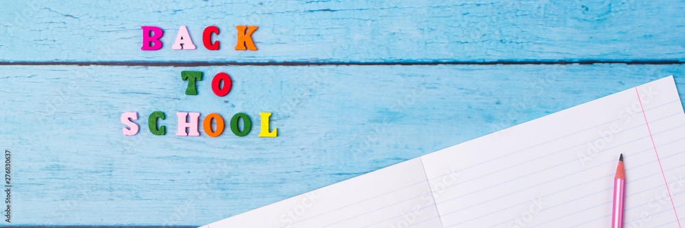 Obraz premium Layout of school supplies on a blue wooden background. The view from the top. Back to school. Flat lay.