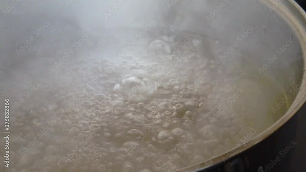 Slow motion clip of a stainless steel saucepan of water and olive oil at a rolling boil. Slow motion clip of a stainless steel saucepan of water and olive oil at a rolling boil.