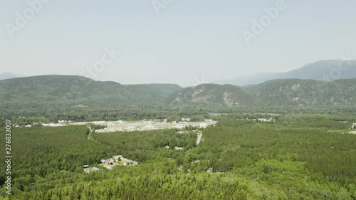 An aerial, cinematic, moving view of the outskirts of town, shot in Terrace, B.C. Canada during the summer months on a sunny day. photo