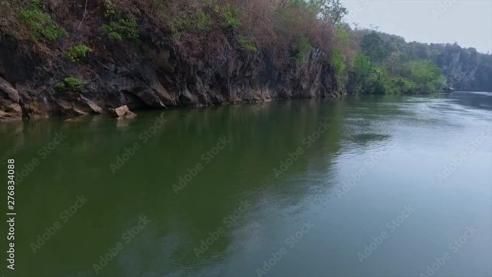 An extreme close up of a river bordered on by a cliff and green plants An extreme close up of a river bordered on by a cliff and green plants