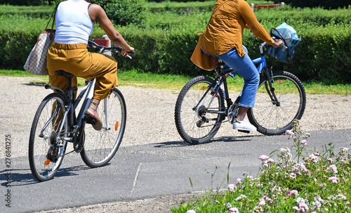 Women are riding on bicycles in the park