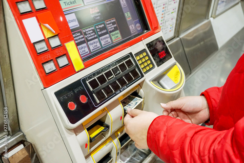 Hand of people purchasing subway tickets through Japanese automated ticket machines at subway station in Osaka city.