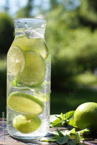 A bottle of natural mojito cocktail on the table in the garden