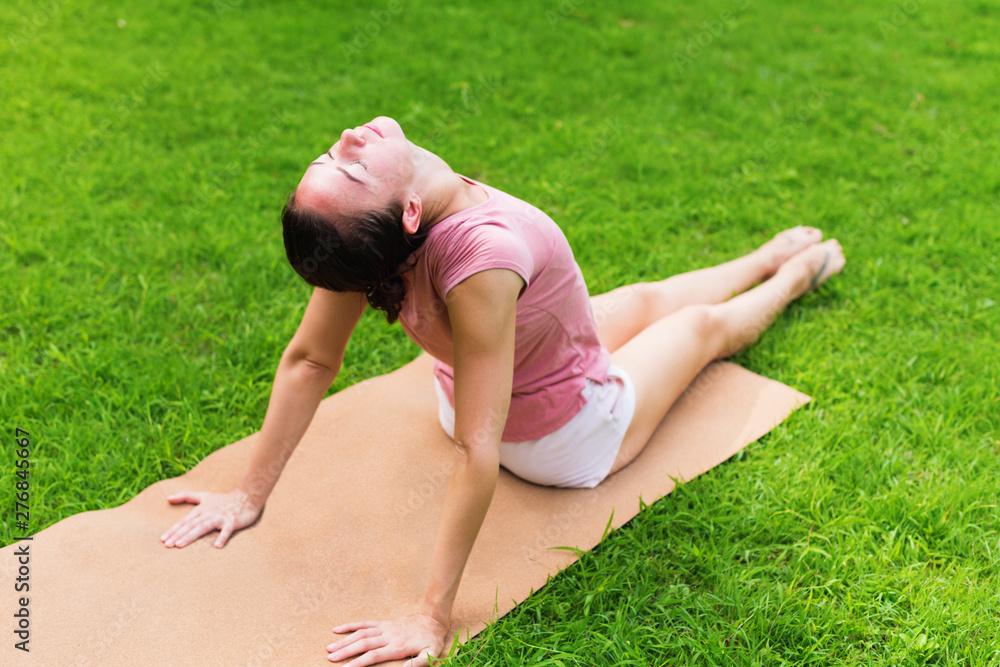Girl doing yoga on open air on natural meadow Girl doing yoga on open air on natural meadow