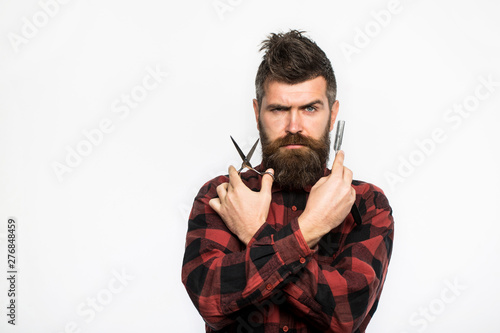 Bearded man, long beard, brutal, caucasian hipster with moustache. Mens haircut in barber shop. Barber scissors and straight razor, barber shop. Mens haircut, shaving. Male in barbershop.