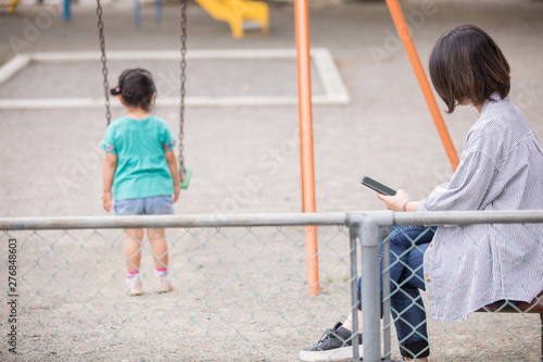 公園で子供が一人で遊び母親が放置し携帯電話使っている Stock 写真 Adobe Stock 公園で子供が一人で遊び母親が放置し携帯電話使っている Stock 写真 Adobe Stock
