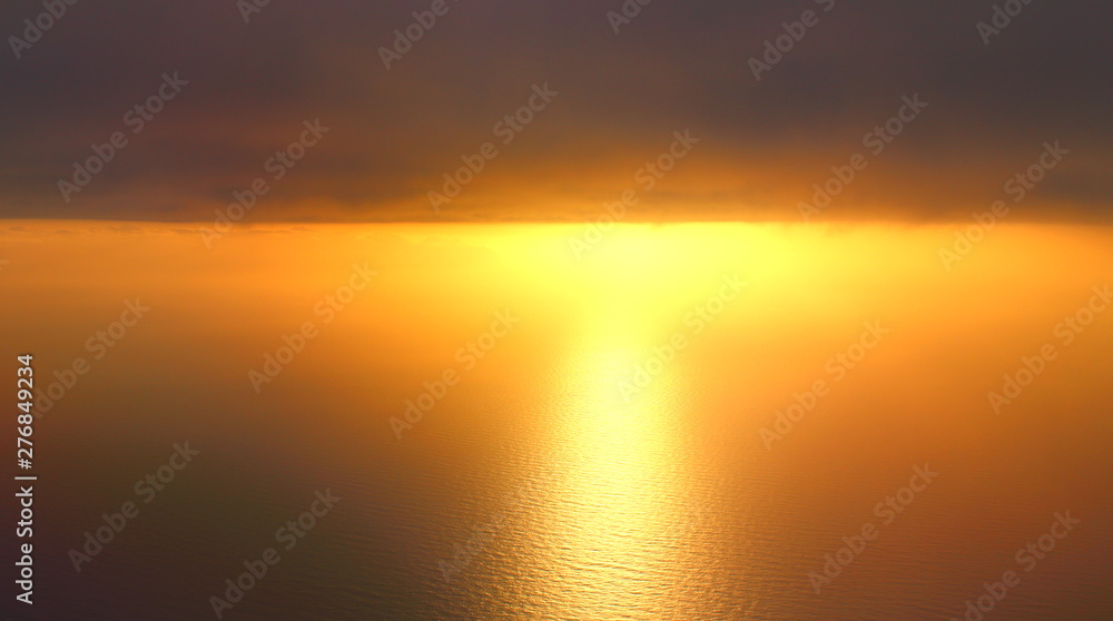 evocative imagine of sunset over the sea from the plane with clouds in the background