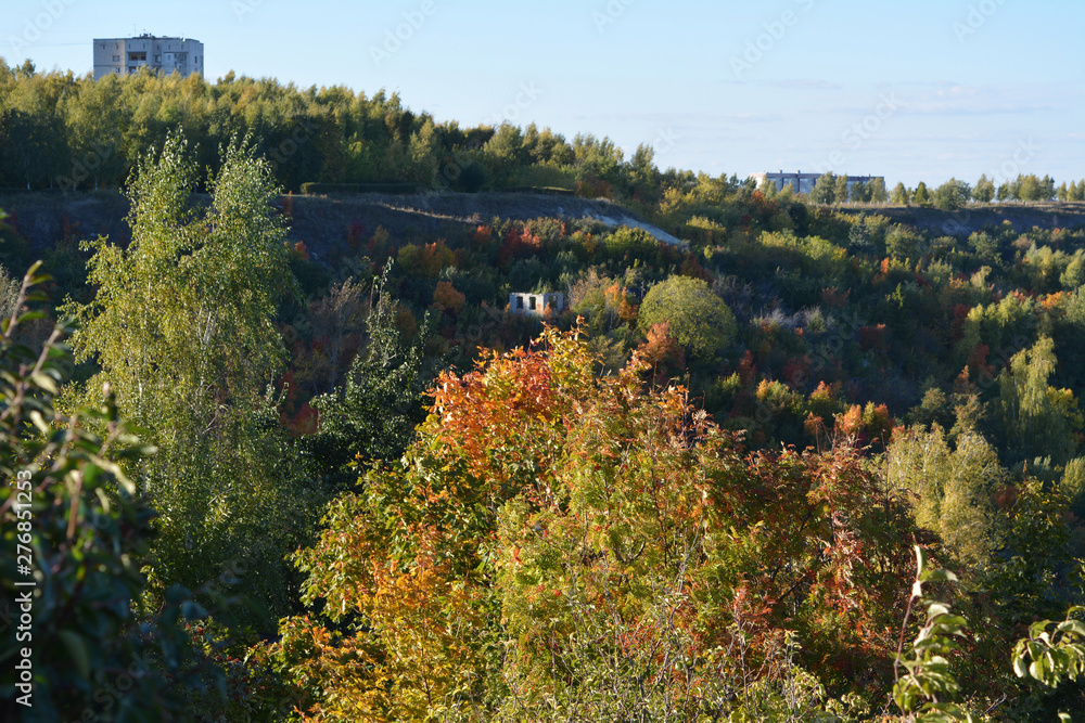 Abandoned park on a hillside in the fall. Landscape with bright trees in autumn.