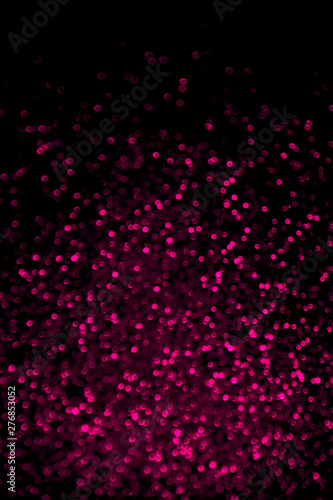Abstract plastic pink glitter confetti sparkles on black background. Holiday background. Festive concept.