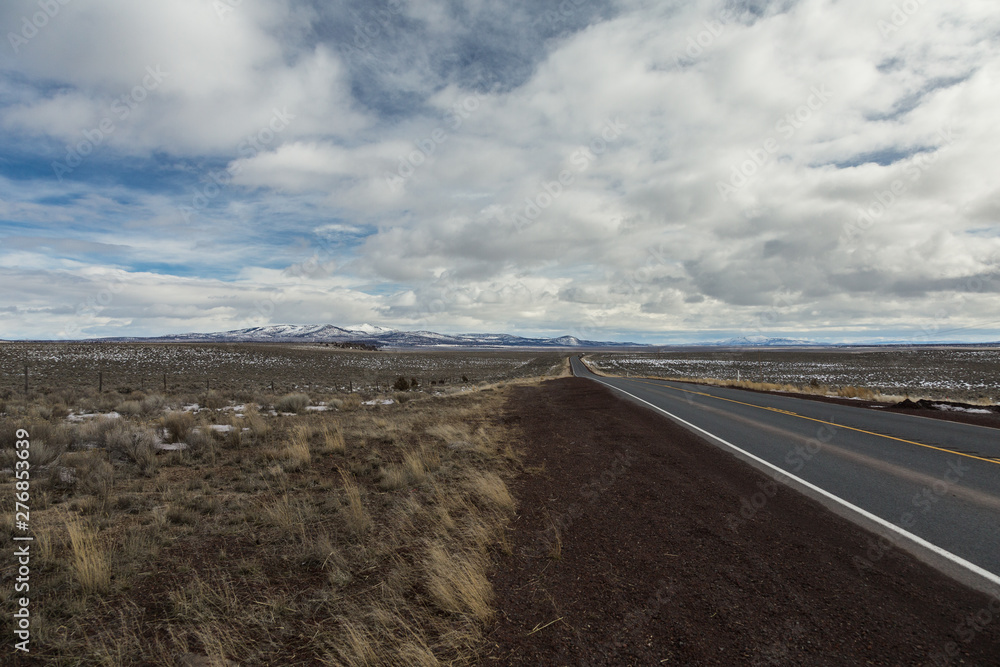 Road ahead with overcast sky above mountain