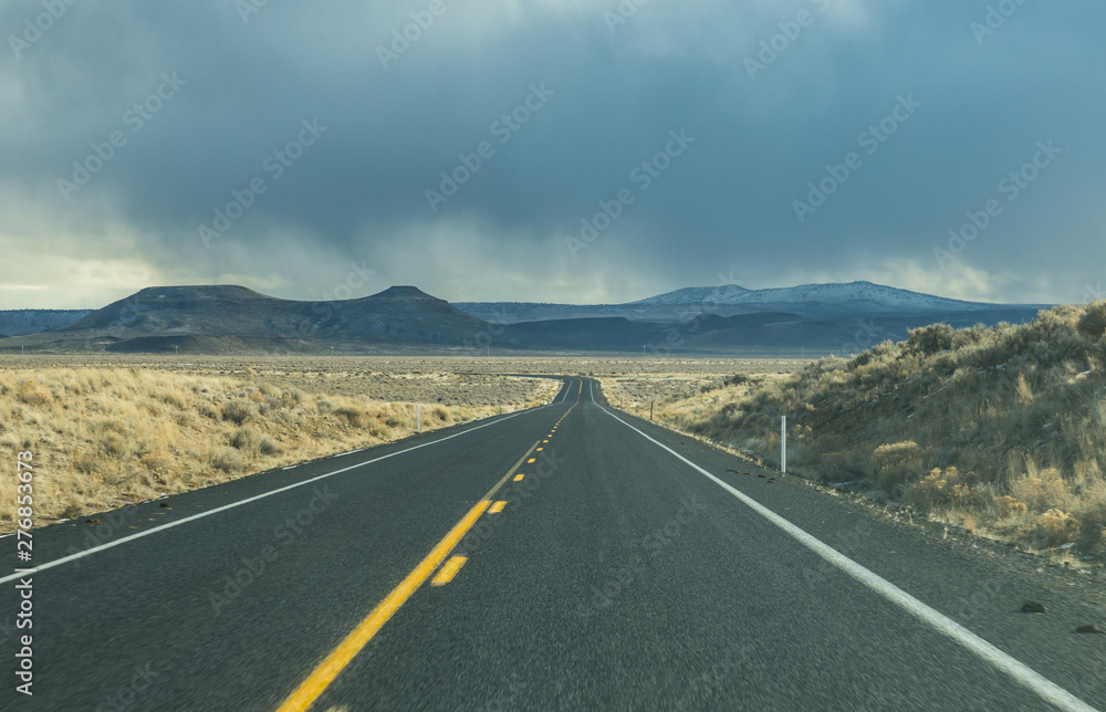 Road ahead with storm clouds above mountain in Oregon, USA