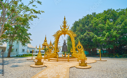 Ritual bell in golden arch of White Temple, Chiang Rai, Thailand photo