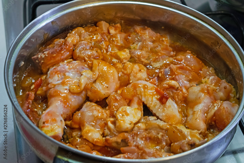 Slices of homemade chicken in a spicy honey sauce in a pan