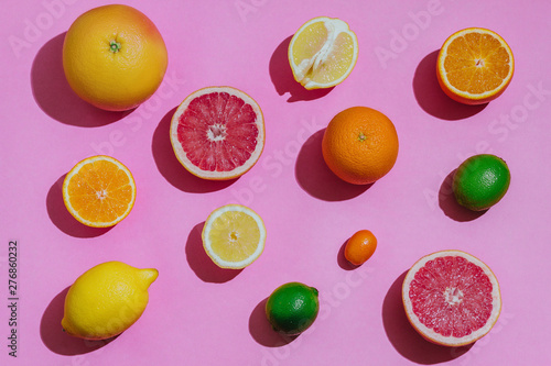Fototapeta Naklejka Na Ścianę i Meble -  Citrus fruits fresh cutted on a pastel pink background closeup separately top view