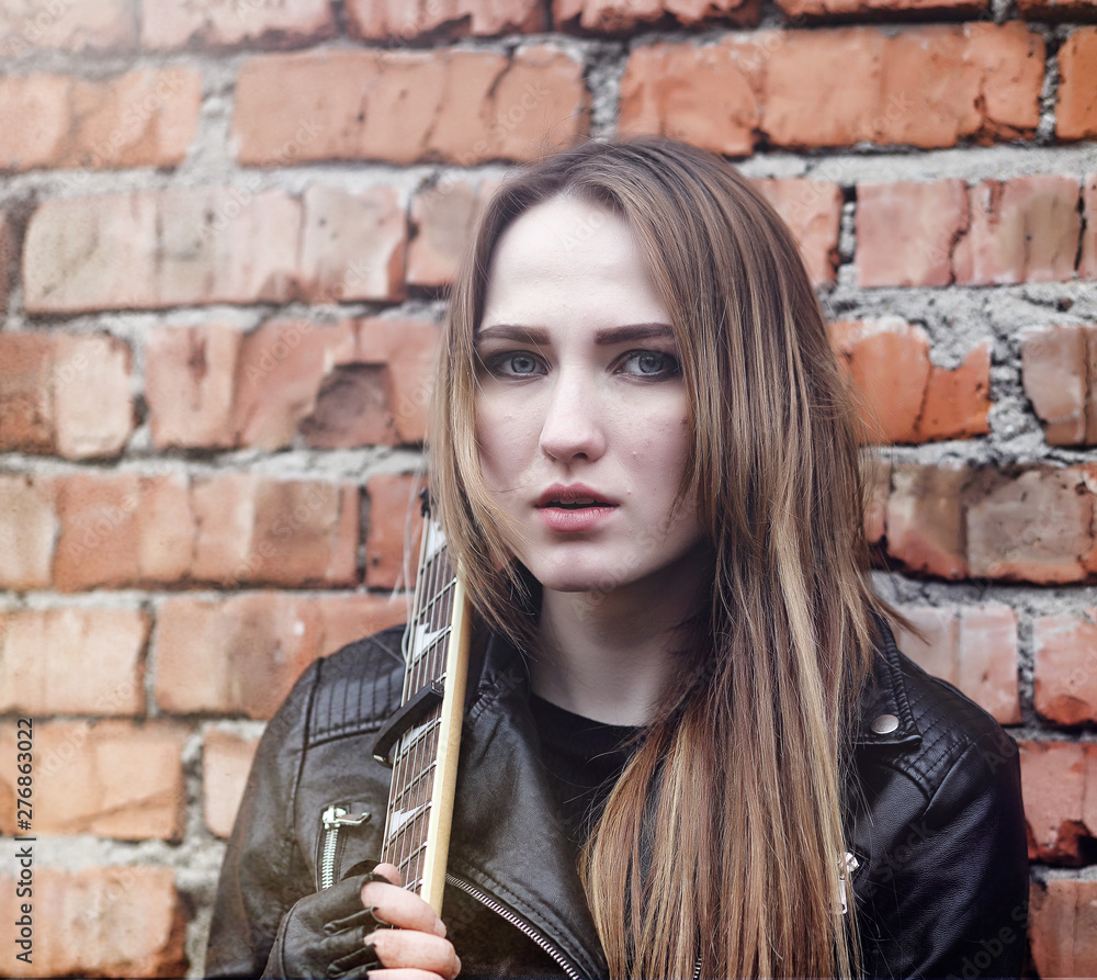 Beautiful young girl rocker with electric guitar. A rock musician girl ...