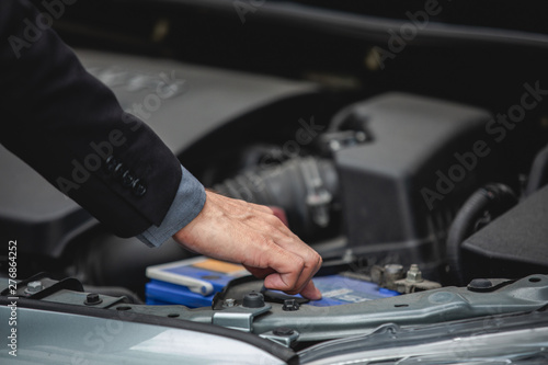 Businessmen help businesswomen check and repair broken cars