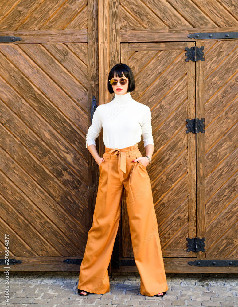 Woman attractive brunette wear fashionable clothes. Femininity and emphasize feminine figure. Girl wear loose high waisted pants. Fashion shop. High waisted pants fashion trend. High waisted trousers