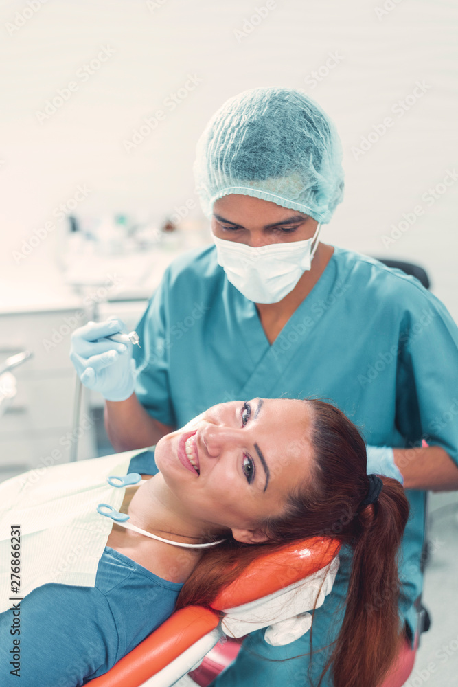 Dentist clening the teeth of a pacient in the dentistry Dentist clening the teeth of a pacient in the dentistry
