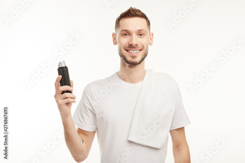 Smiling man wearing perfume on white background