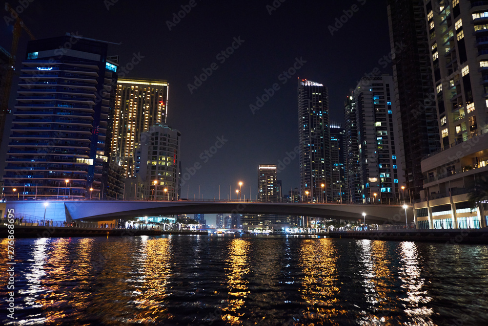 Dubai Marina at night with colorful touristic boats