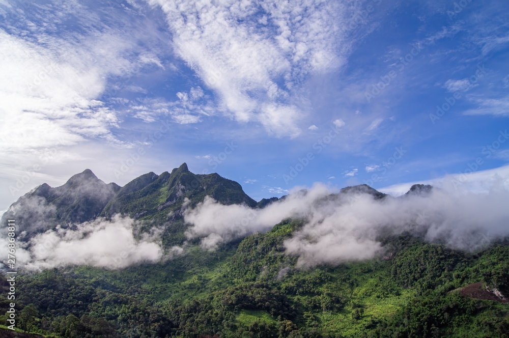 Green mountain scenery There is a mist in the mountains and mountains The sky is blue and the clouds are white.