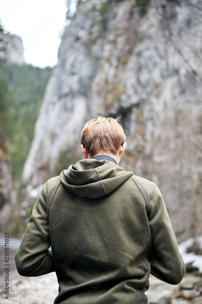 Young blonde adult male taking photos in Bicaz keys