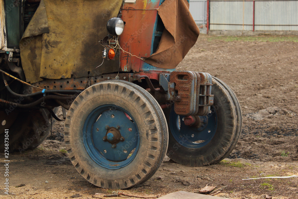 Obraz stary zardzewiały wyblakły traktor z bliska w stoczni