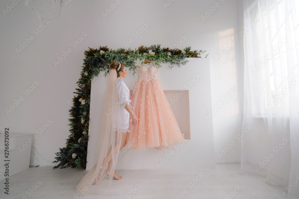 Bride in bathrobe admiring her wedding dress Bride in bathrobe admiring her wedding dress