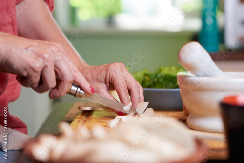 Close-up shot of woman hands cutting mushrooms