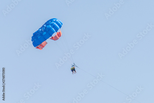 Two persons on a parasailing in the sky