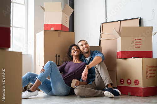 Cuadro en lienzo Multiethnic couple in new home with boxes