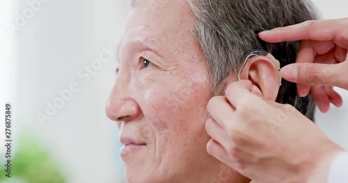 Doctor help patient wear audiphone photo