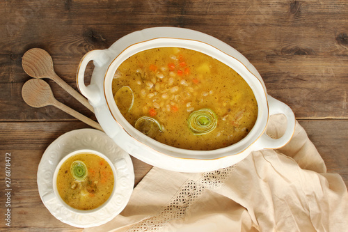 Foto fresh hot bean soup in a white plate and white tureen on an old wooden table