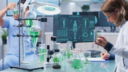 In busy biotechnology center biologist is looking at plant samples. Modern laboratory