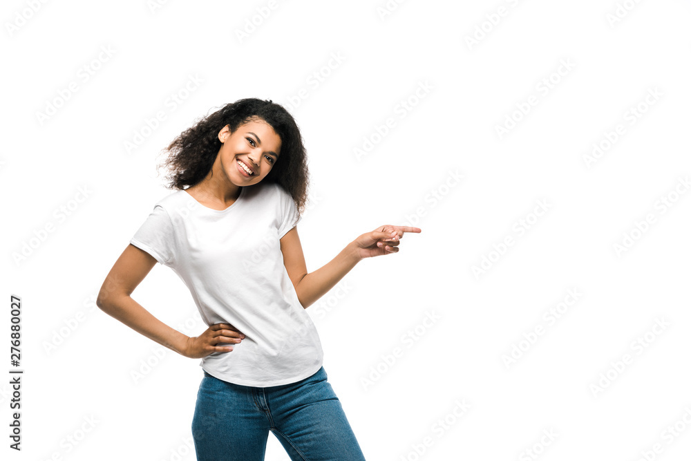 happy african american girl in white t-shirt pointing with finger while standing with hand on hip isolated on white happy african american girl in white t-shirt pointing with finger while standing with hand on hip isolated on white