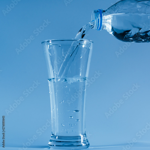 Pour water from the bottle into the glass