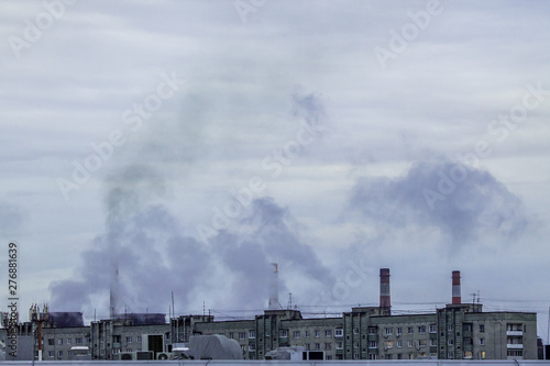 industrial chimneys on cloudy sky background with heavy smoke causing air pollution as environmental problem