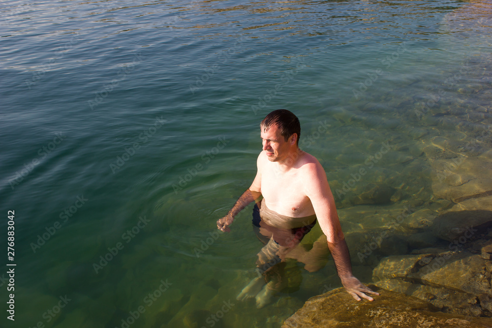 Fototapeta premium Male young swimmer on the water - summer sea