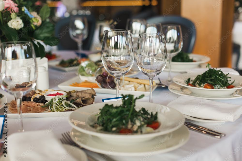 Fototapeta premium of the dishes and food on the served table. long served feast table.festive table in the restaurant.Interior of the banquet hall in the cafe.banquet table in the restaurant.place of celebration