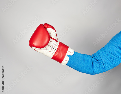 man's hand is wearing a red leather boxing glove © nndanko