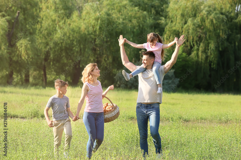 Obraz premium Happy family walking in park on summer day
