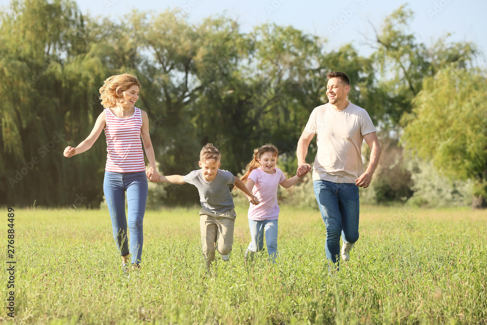 Happy family running in park on summer day Happy family running in park on summer day