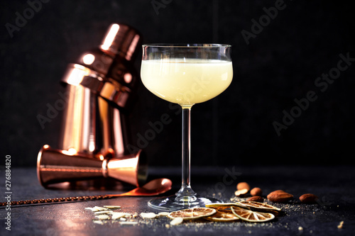 Full cocktail glass, some fruit slices, almonds and pro bartending equipment