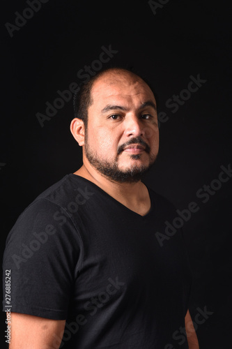 portrait of a latin american man on black background © curto
